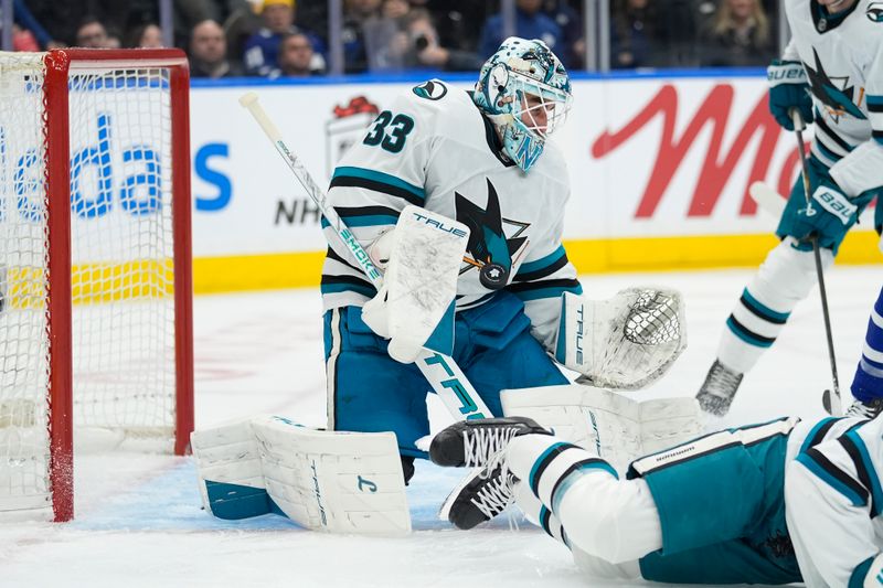 Dec 11, 2025; Toronto, Ontario, CAN; San Jose Sharks goaltender Alex Nedeljkovic (33) makes a save against the Toronto Maple Leafs during during the first period at Scotiabank Arena. Mandatory Credit: John E. Sokolowski-Imagn Images