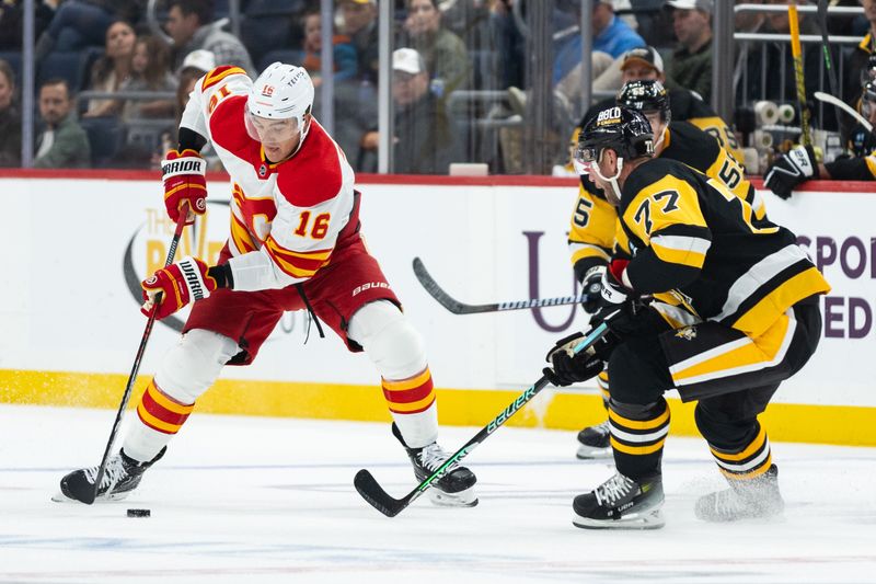 Oct 14, 2023; Pittsburgh, Pennsylvania, USA; Calgary Flames defenseman Nikita Zadorov (16) skates the puck as Pittsburgh Penguins center Jeff Carter (77) steps up to challenge him during the second period at PPG Paints Arena. Mandatory Credit: Scott Galvin-USA TODAY Sports