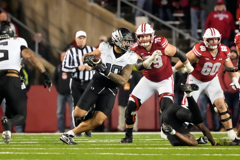 Nov 16, 2024; Madison, Wisconsin, USA;  Oregon Ducks linebacker Matayo Uiagalelei (10) intercepts a pass during the fourth quarter against the Wisconsin Badgers at Camp Randall Stadium. Mandatory Credit: Jeff Hanisch-Imagn Images