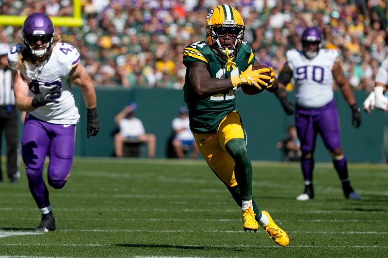 Green Bay Packers wide receiver Jayden Reed (11) runs for a first down after a catch past Minnesota Vikings defenders during the first half of an NFL football game Sunday, Sept. 29, 2024, in Green Bay, Wis. (AP Photo/Morry Gash)