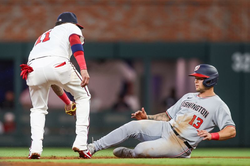 May 30, 2024; Atlanta, Georgia, USA; Atlanta Braves shortstop Orlando Arcia (11) tags out Washington Nationals third baseman Nick Senzel (13) in the eighth inning at Truist Park. Mandatory Credit: Brett Davis-USA TODAY Sports
