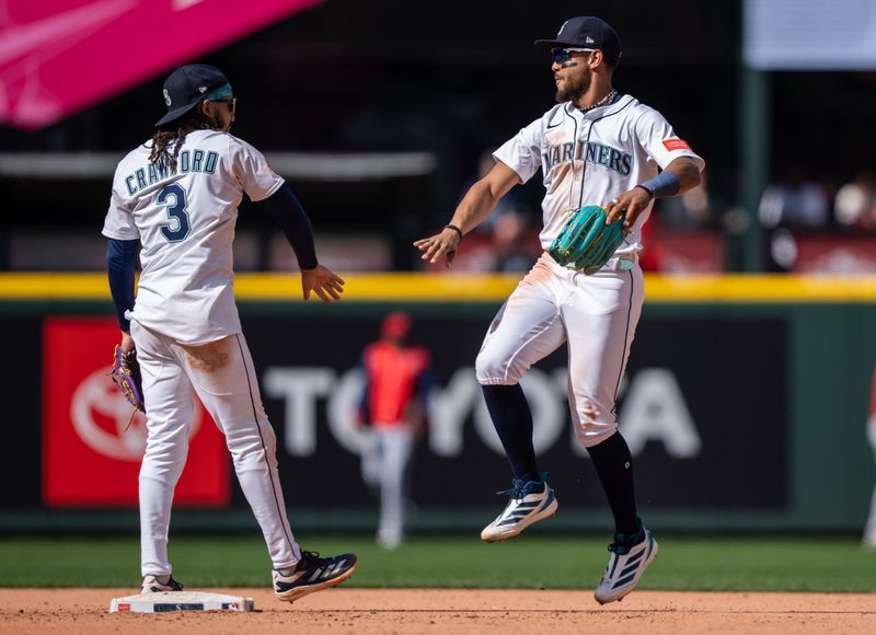 Apr 30, 2025; Seattle, Washington, USA;  Seattle Mariners centerfielder Julio Rodriguez (44) and shortstop J.P. Crawford (3) celebrate after a game against the Los Angeles Angels at T-Mobile Park. Mandatory Credit: Stephen Brashear-Imagn Images