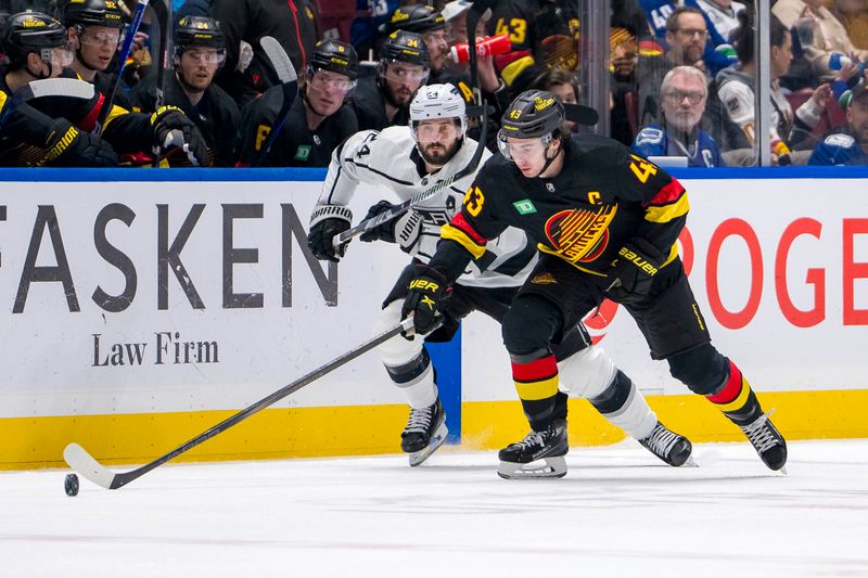 Mar 25, 2024; Vancouver, British Columbia, CAN;  Los Angeles Kings forward Phillip Danault (24) watches as Vancouver Canucks defenseman Quinn Hughes (43) handles the puck in the second period at Rogers Arena. Mandatory Credit: Bob Frid-USA TODAY Sports