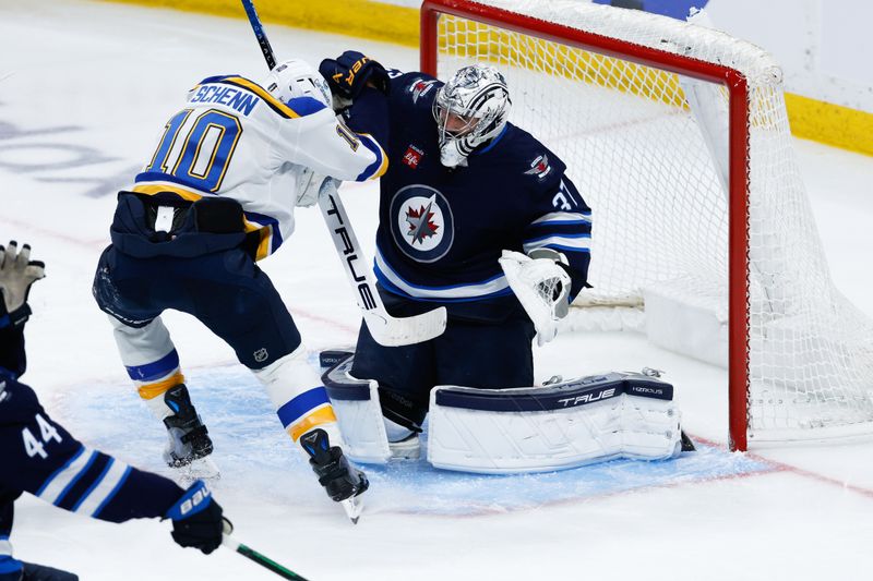 Apr 30, 2025; Winnipeg, Manitoba, CAN; Winnipeg Jets goalie Connor Hellebuyck (37) avoids St. Louis Blues forward Brayden Schenn (10) during the third period in game five of the first round of the 2025 Stanley Cup Playoffs at Canada Life Centre. Mandatory Credit: Terrence Lee-Imagn Images