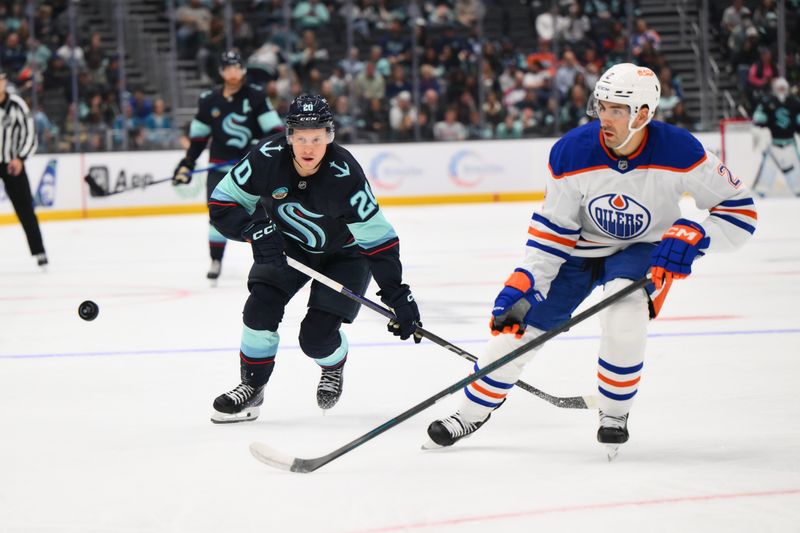 Oct 2, 2024; Seattle, Washington, USA; Seattle Kraken right wing Eeli Tolvanen (20) and Edmonton Oilers defenseman Evan Bouchard (2) chase the puck during the third period at Climate Pledge Arena. Mandatory Credit: Steven Bisig-Imagn Images