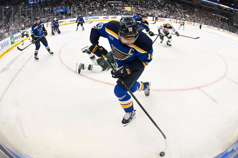 Nov 19, 2024; St. Louis, Missouri, USA;  St. Louis Blues center Brayden Schenn (10) controls the puck against the Minnesota Wild during the first period at Enterprise Center. Mandatory Credit: Jeff Curry-Imagn Images