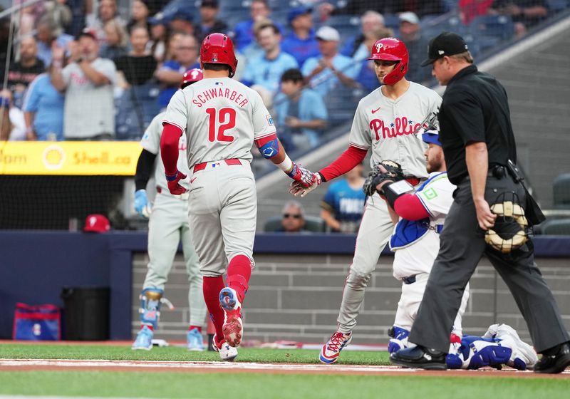 Sep 3, 2024; Toronto, Ontario, CAN; Philadelphia Phillies designated hitter Kyle Schwarber (12) hits a home run and celebrates with Philadelphia Phillies shortstop Trea Turner (7) against the Toronto Blue Jays during the first inning at Rogers Centre. Mandatory Credit: Nick Turchiaro-Imagn Images