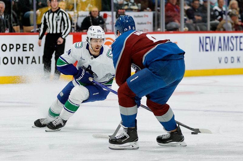 Apr 10, 2025; Denver, Colorado, USA; Vancouver Canucks center Pius Suter (24) controls the puck as Colorado Avalanche defenseman Cale Makar (8) defends in the first period at Ball Arena. Mandatory Credit: Isaiah J. Downing-Imagn Images