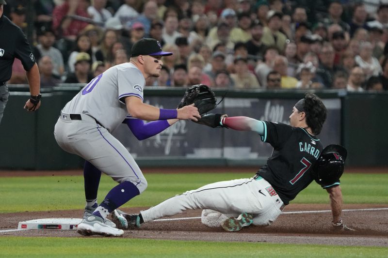 Aug 14, 2024; Phoenix, Arizona, USA; Arizona Diamondbacks outfielder Corbin Carroll (7) slides into third base against Colorado Rockies third base Aaron Schunk (30) in the first inning at Chase Field. Mandatory Credit: Rick Scuteri-USA TODAY Sports