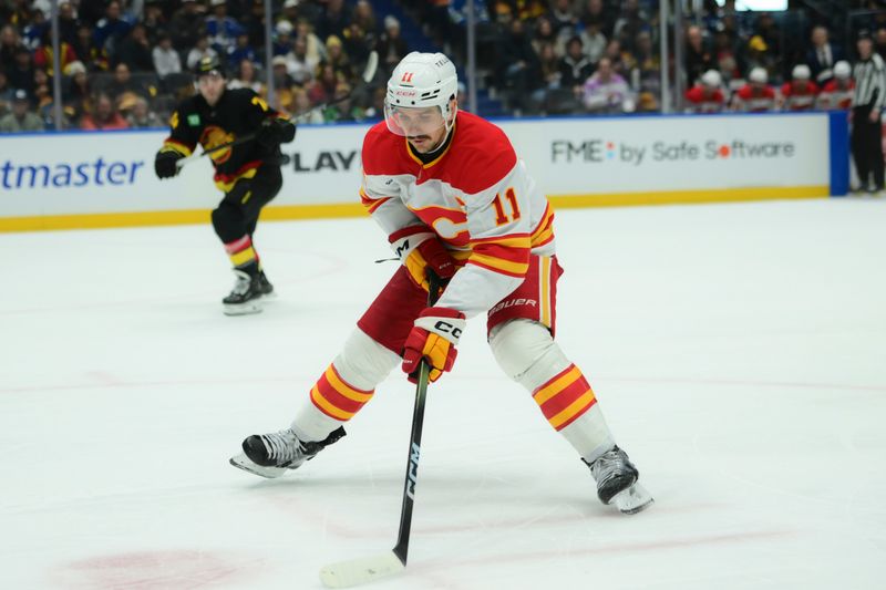 Nov 23, 2025; Vancouver, British Columbia, CAN;  Calgary Flames center Mikael Backlund (11) skates with the puck during the second period against the Vancouver Canucks at Rogers Arena. Mandatory Credit: Simon Fearn-Imagn Images