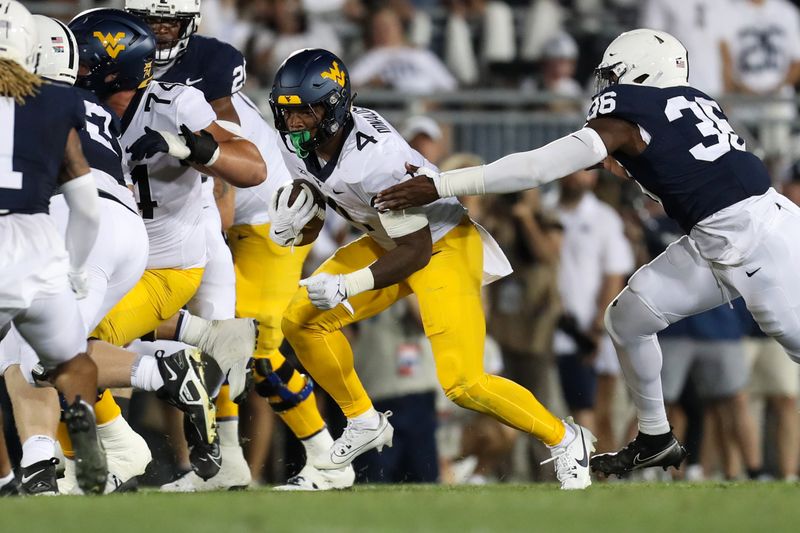 Sep 2, 2023; University Park, Pennsylvania, USA; West Virginia Mountaineers running back CJ Donaldson Jr. (4) runs with the ball while breaking a tackle from Penn State Nittany Lions defensive end Zuriah Fisher (36) during the third quarter at Beaver Stadium. Penn State defeated West Virginia 38-15. Mandatory Credit: Matthew O'Haren-USA TODAY Sports