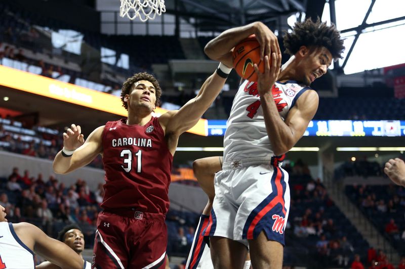 Feb 11, 2023; Oxford, Mississippi, USA; Mississippi Rebels forward Jaemyn Brakefield (4) collects a rebound over South Carolina Gamecocks forward Benjamin Bosmans-Verdonk (31) during the first half at The Sandy and John Black Pavilion at Ole Miss. Mandatory Credit: Petre Thomas-USA TODAY Sports