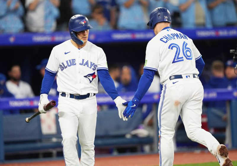 Sep 29, 2023; Toronto, Ontario, CAN; Toronto Blue Jays third baseman Matt Chapman (26) celebrates with left fielder Daulton Varsho (25) after hitting a home run against the Tampa Bay Rays during the fifth inning at Rogers Centre. Mandatory Credit: Nick Turchiaro-USA TODAY Sports