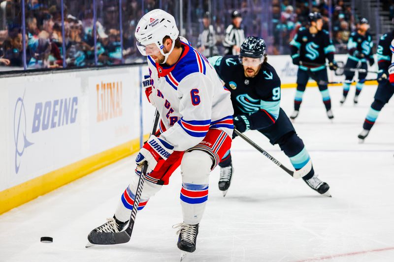 Nov 17, 2024; Seattle, Washington, USA; New York Rangers defenseman Zac Jones (6) recovers a loose puck against the Seattle Kraken during the first period at Climate Pledge Arena. Mandatory Credit: Joe Nicholson-Imagn Images