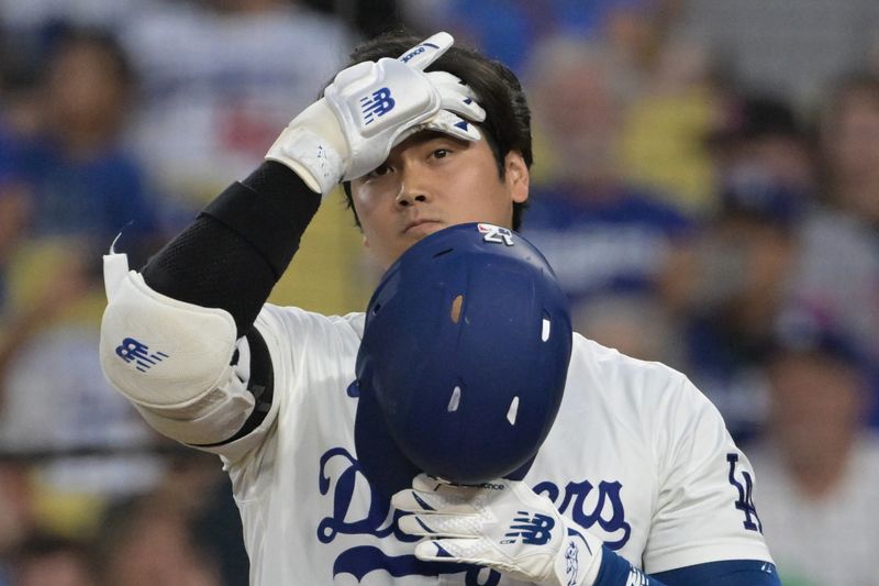 Aug 6, 2024; Los Angeles, California, USA;  Los Angeles Dodgers designated hitter Shohei Ohtani (17) adjusts his batting helmet in the third inning against the Philadelphia Phillies at Dodger Stadium. Mandatory Credit: Jayne Kamin-Oncea-USA TODAY Sports