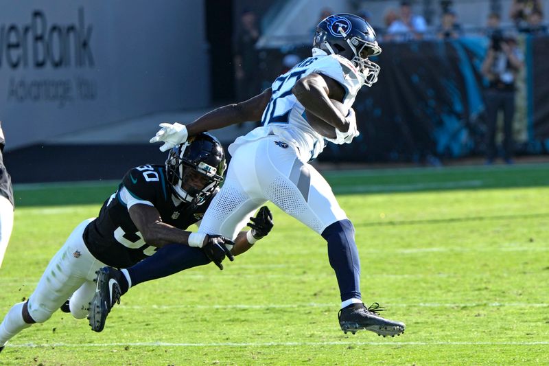 Tennessee Titans running back Tyjae Spears (32) is stopped by Jacksonville Jaguars cornerback Montaric Brown (30) after a short gain during the second half of an NFL football game, Sunday, Nov. 19, 2023, in Jacksonville, Fla. (AP Photo/John Raoux)