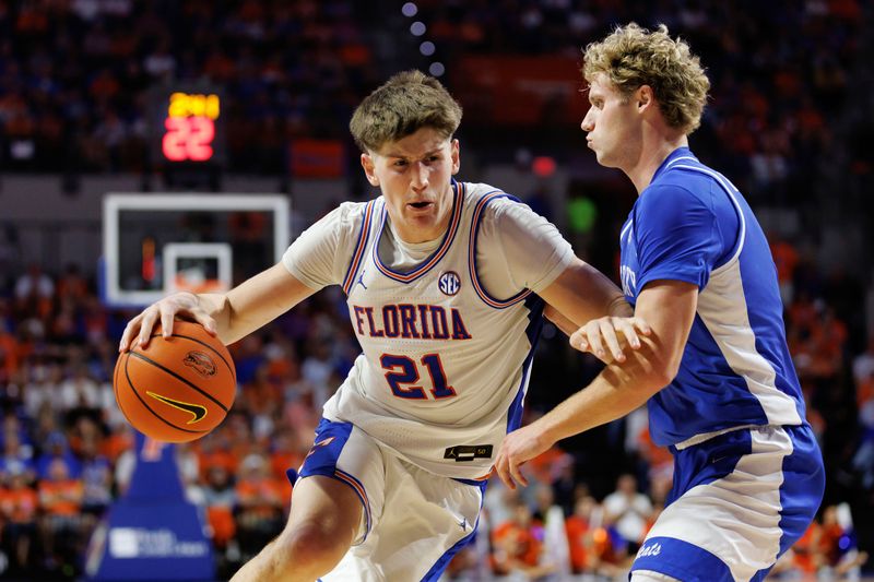 Feb 14, 2026; Gainesville, Florida, USA; Florida Gators forward Alex Condon (21) drives to the basket at Kentucky Wildcats guard Collin Chandler (5) during the second half at Exactech Arena at the Stephen C. O'Connell Center. Mandatory Credit: Matt Pendleton-Imagn Images
