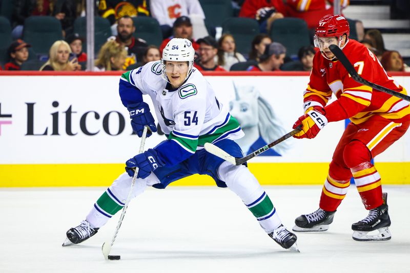 Sep 28, 2024; Calgary, Alberta, CAN; Vancouver Canucks center Aatu Raty (54) controls the puck against the Calgary Flames during the third period at Scotiabank Saddledome. Mandatory Credit: Sergei Belski-Imagn Images