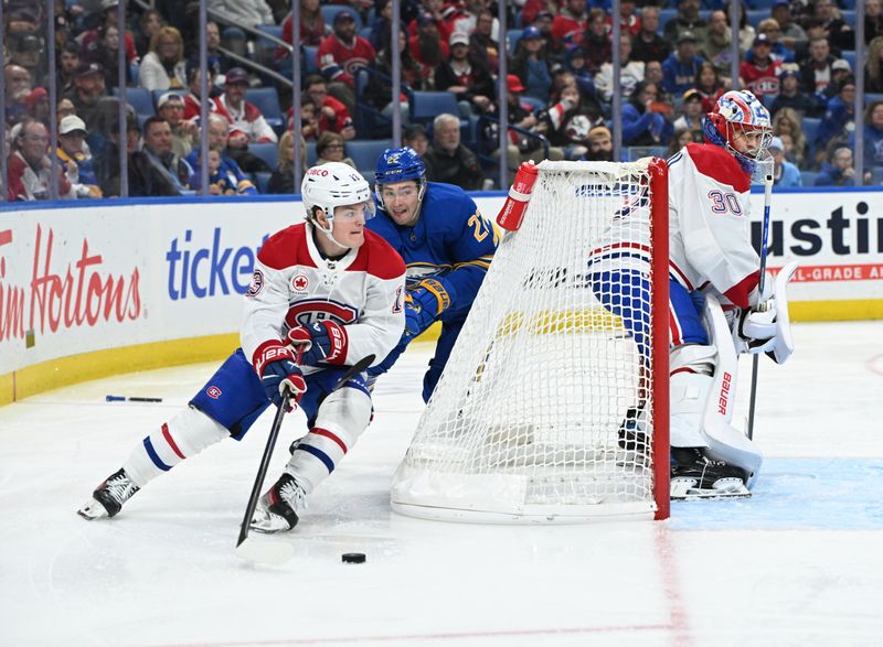 Nov 11, 2024; Buffalo, New York, USA; Montreal Canadiens right wing Cole Caufield (13) handles the puck behind the goal with goaltender Cayden Primeau (30) and Buffalo Sabres right wing Jack Quinn (22) nearby in the second period at KeyBank Center. Mandatory Credit: Mark Konezny-Imagn Images