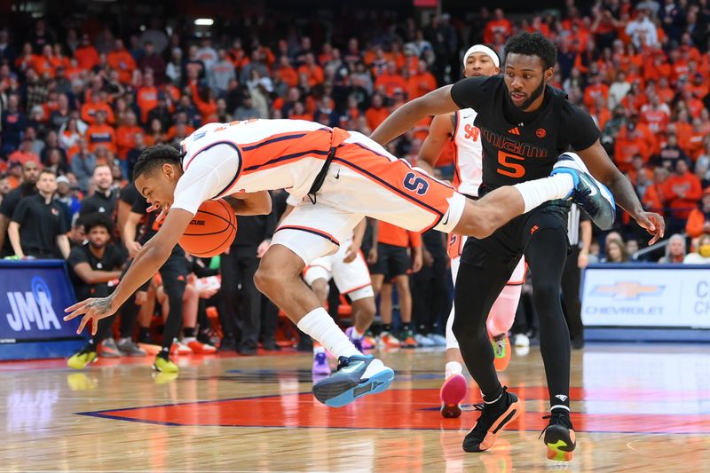 Jan 20, 2024; Syracuse, New York, USA; Syracuse Orange guard Judah Mintz (3) goes airborne as Miami (Fl) Hurricanes guard Wooga Poplar (5) defends during the first half at the JMA Wireless Dome. Mandatory Credit: Rich Barnes-USA TODAY Sports