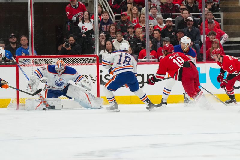 Nov 15, 2025; Raleigh, North Carolina, USA;  Edmonton Oilers goaltender Stuart Skinner (74) stops the shot by Carolina Hurricanes defenseman K'Andre Miller (19) during the second period at Lenovo Center. Mandatory Credit: James Guillory-Imagn Images