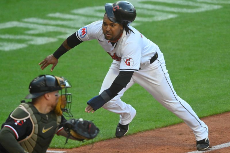 May 18, 2024; Cleveland, Ohio, USA; Cleveland Guardians third baseman Jose Ramirez (11) starts his slide before being tagged out by Minnesota Twins catcher Christian Vazquez (8) in the third inning at Progressive Field. Mandatory Credit: David Richard-USA TODAY Sports