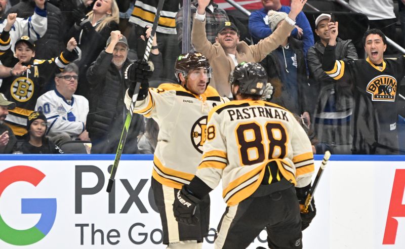 Dec 2, 2023; Toronto, Ontario, CAN; Boston Bruins forward Brad Marchand (63) celebrates with forward David Pastrnak (88) after scoring the game winning goal in overtime against the Toronto Maple Leafs at Scotiabank Arena. Mandatory Credit: Dan Hamilton-USA TODAY Sports