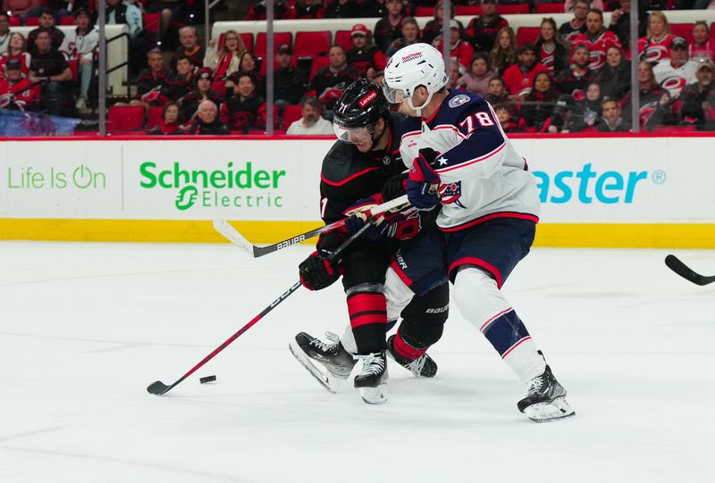 Apr 7, 2024; Raleigh, North Carolina, USA;  Carolina Hurricanes right wing Jesper Fast (71) and Columbus Blue Jackets defenseman Damon Severson (78) battle over the puck during the third period at PNC Arena. Mandatory Credit: James Guillory-USA TODAY Sports