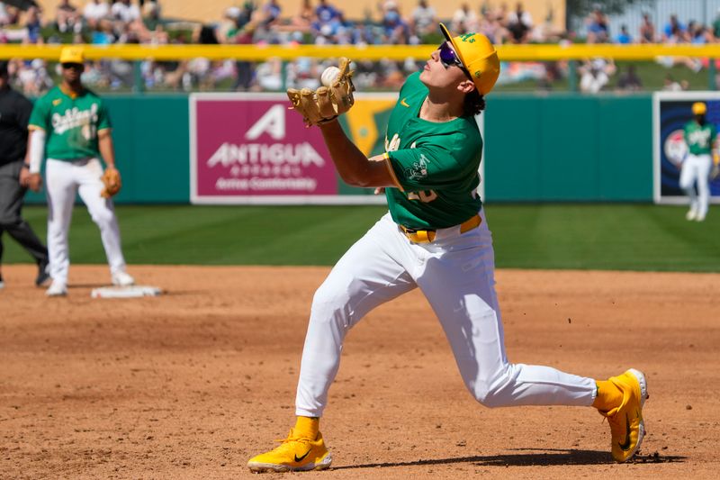 Mar 10, 2024; Mesa, Arizona, USA; Oakland Athletics second baseman Zack Gelof (20) makes the off balance catch an out against the Kansas City Royals in the third inning at Hohokam Stadium. Mandatory Credit: Rick Scuteri-USA TODAY Sports