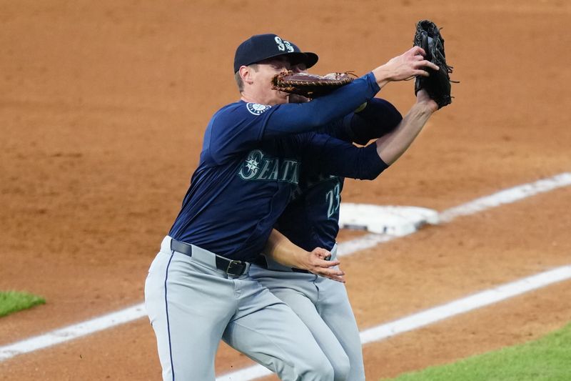Apr 21, 2024; Denver, Colorado, USA; Seattle Mariners starting pitcher Emerson Hancock (62) and first base Ty France (23) collide fielding a pop fly in the fourth inning against the Colorado Rockies at Coors Field. Mandatory Credit: Ron Chenoy-USA TODAY Sports