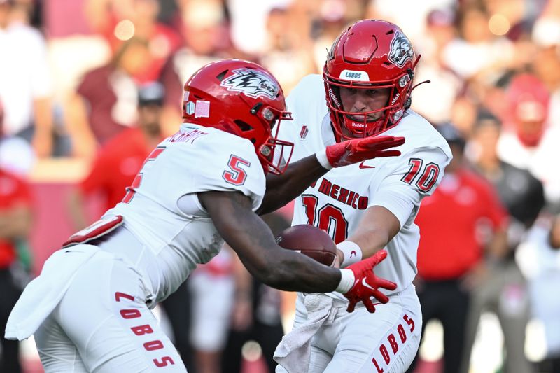 Sep 2, 2023; College Station, Texas, USA; New Mexico Lobos quarterback Dylan Hopkins (10) hands off the battle to New Mexico Lobos running back Jacory Croskey-Merritt (5) during the first quarter against the Texas A&M Aggies at Kyle Field. Mandatory Credit: Maria Lysaker-USA TODAY Sports