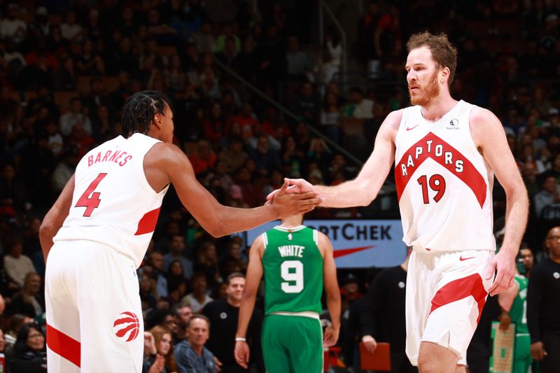 TORONTO, CANADA - OCTOBER 15: Jakob Poeltl #19 and Scottie Barnes #4 of the Toronto Raptors high five during the game against the Boston Celtics on October 15, 2024 at the Scotiabank Arena in Toronto, Ontario, Canada.  NOTE TO USER: User expressly acknowledges and agrees that, by downloading and or using this Photograph, user is consenting to the terms and conditions of the Getty Images License Agreement.  Mandatory Copyright Notice: Copyright 2024 NBAE (Photo by Vaughn Ridley/NBAE via Getty Images)