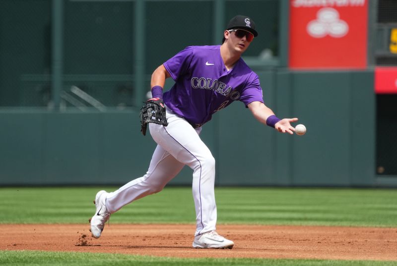 Jul 30, 2023; Denver, Colorado, USA; Colorado Rockies first baseman Michael Toglia (4) fields the ball in the first inning against the Oakland Athletics at Coors Field. Mandatory Credit: Ron Chenoy-USA TODAY Sports