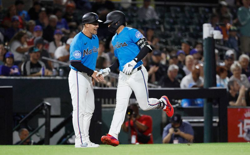 Mar 6, 2026; Jupiter, Florida, USA;  Miami Marlins third base coach Blake Lalli (45) greets third baseman Connor Norby (1) after his solo home run against the New York Mets during the first inning at Roger Dean Chevrolet Stadium. Mandatory Credit: Rhona Wise-Imagn Images