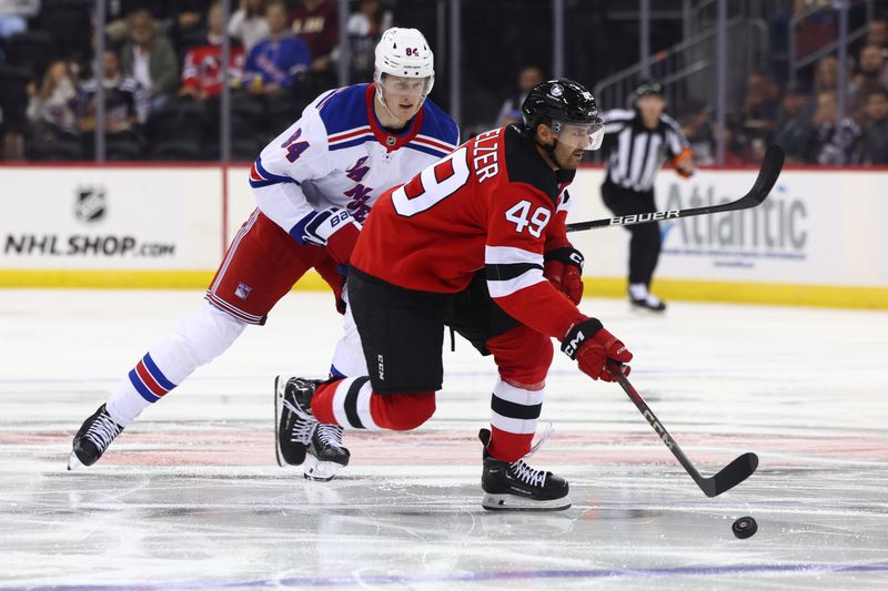 Sep 30, 2024; Newark, New Jersey, USA; New Jersey Devils center Ryan Schmelzer (49) skates with the puck against the New York Rangers during the second period at Prudential Center. Mandatory Credit: Ed Mulholland-Imagn Images