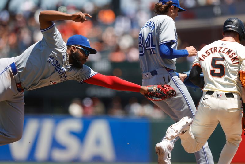 Jul 11, 2024; San Francisco, California, USA; Toronto Blue Jays first base Vladimir Guerrero Jr. (27) dives to tag San Francisco Giants outfielder Mike Yastrzemski (5) during the fourth inning at Oracle Park. Mandatory Credit: Sergio Estrada-USA TODAY Sports