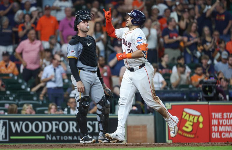 Jul 30, 2024; Houston, Texas, USA; Pittsburgh Pirates catcher Joey Bart (14) blows a bubble as Houston Astros catcher Yainer Diaz (21) scores a run after hitting a home run during the fourth inning at Minute Maid Park. Mandatory Credit: Troy Taormina-USA TODAY Sports