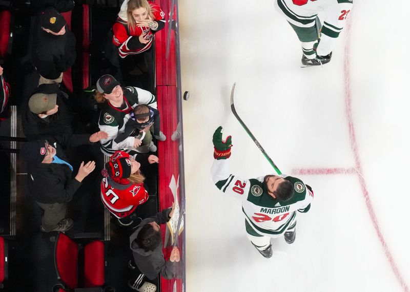 Jan 21, 2024; Raleigh, North Carolina, USA;  Minnesota Wild left wing Pat Maroon (20) tosses a puck to the fans before the game against the Carolina Hurricanes at PNC Arena. Mandatory Credit: James Guillory-USA TODAY Sports