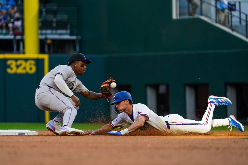 May 12, 2025; Arlington, Texas, USA; Texas Rangers outfielder Evan Carter (32) steals second base as Colorado Rockies second baseman Adael Amador (1) awaits the throw during the first inning at Globe Life Field. Mandatory Credit: Raymond Carlin III-Imagn Images