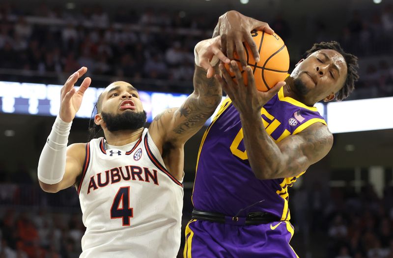 Jan 13, 2024; Auburn, Alabama, USA; LSU Tigers guard Trae Hannibal (0) and Auburn Tigers forward Johni Broome (4) fight for control of a rebound during the second half at Neville Arena. Mandatory Credit: John Reed-USA TODAY Sports