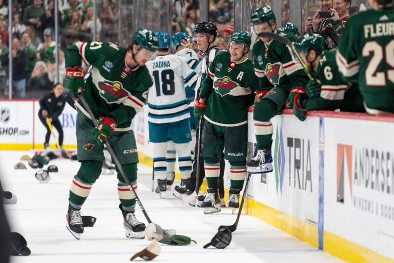 Mar 3, 2024; Saint Paul, Minnesota, USA; Minnesota Wild left wing Kirill Kaprizov (97) celebrates his third goal of the game against the San Jose Sharks while teammate Minnesota Wild right wing Brandon Duhaime (21) picks up hats thrown on the ice. in the third period at Xcel Energy Center. Mandatory Credit: Matt Blewett-USA TODAY Sports