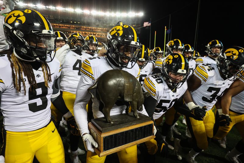 Nov 19, 2022; Minneapolis, Minnesota, USA; Iowa Hawkeyes players celebrate with the Floyd of Rosedale after defeating the Minnesota Golden Gophers at Huntington Bank Stadium. Mandatory Credit: Matt Krohn-USA TODAY Sports