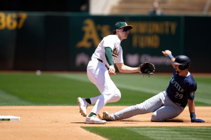 Jun 6, 2024; Oakland, California, USA; Seattle Mariners catcher Cal Raleigh (29) slides safely into second base with a steal as Oakland Athletics second baseman Zack Gelof (20) awaits the late throw during the fourth inning at Oakland-Alameda County Coliseum. Mandatory Credit: D. Ross Cameron-USA TODAY Sports