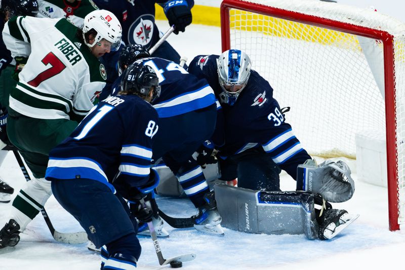 Feb 20, 2024; Winnipeg, Manitoba, CAN; Winnipeg Jets forward Kyle Connor (81) clears the puck away from Minnesota Wild defenseman Brock Faber (7) during the thirdperiod at Canada Life Centre. Mandatory Credit: Terrence Lee-USA TODAY Sports