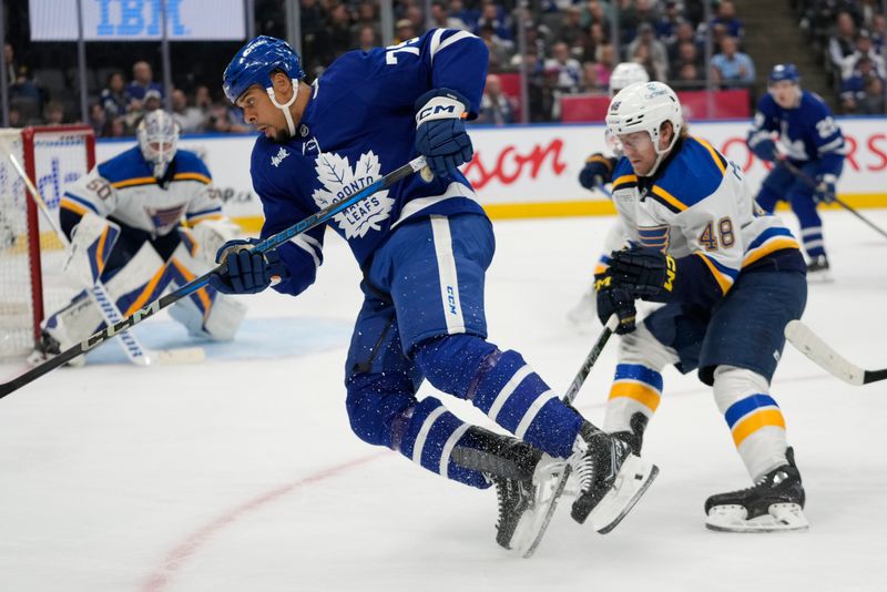 Oct 24, 2024; Toronto, Ontario, CAN; St. Louis Blues defenseman Scott Perunovich (48) trips Toronto Maple Leafs forward Ryan Reaves (75) during the third period at Scotiabank Arena. Mandatory Credit: John E. Sokolowski-Imagn Images