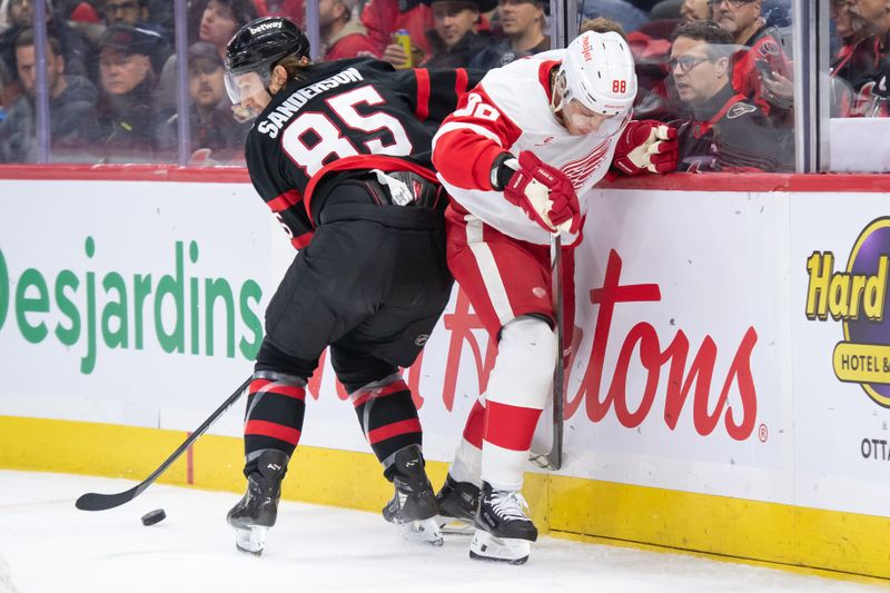 Dec 5, 2024; Ottawa, Ontario, CAN;  Ottawa Senators defenseman Jake Sanderson (85) moves the puck away from Detroit Red Wings right wing Patrick Kane (88) in the second period at the Canadian Tire Centre. Mandatory Credit: Marc DesRosiers-Imagn Images