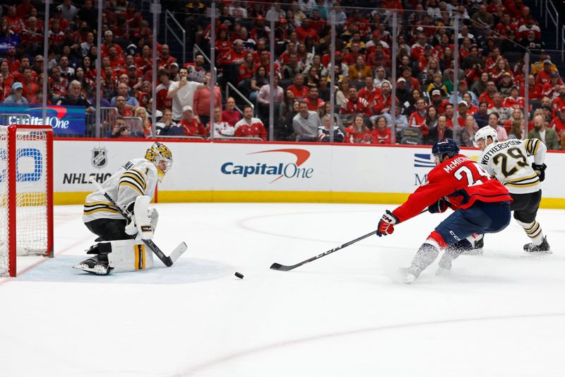 Apr 15, 2024; Washington, District of Columbia, USA; Washington Capitals center Connor McMichael (24) attempts to deflect the puck on Boston Bruins goaltender Jeremy Swayman (1) in the third period at Capital One Arena. Mandatory Credit: Geoff Burke-USA TODAY Sports