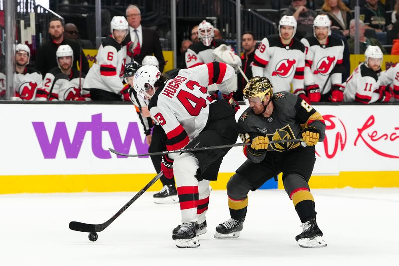 Mar 17, 2024; Las Vegas, Nevada, USA; New Jersey Devils defenseman Luke Hughes (43) keeps the puck away from Vegas Golden Knights right wing Jonathan Marchessault (81) during the third period at T-Mobile Arena. Mandatory Credit: Stephen R. Sylvanie-USA TODAY Sports