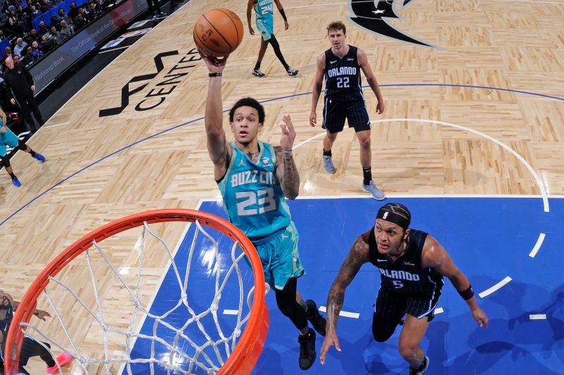 ORLANDO, FL - MARCH 19: Tre Mann #23 of the Charlotte Hornets drives to the basket during the game against the Orlando Magic on March 19, 2024 at the Kia Center in Orlando, Florida. NOTE TO USER: User expressly acknowledges and agrees that, by downloading and or using this photograph, User is consenting to the terms and conditions of the Getty Images License Agreement. Mandatory Copyright Notice: Copyright 2024 NBAE (Photo by Fernando Medina/NBAE via Getty Images)