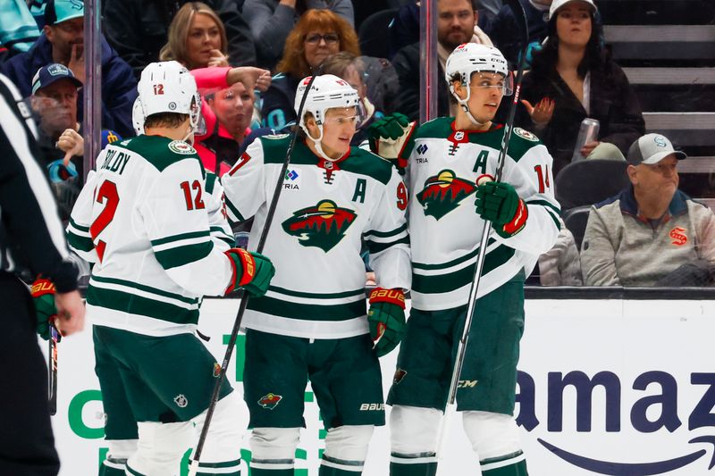 Feb 24, 2024; Seattle, Washington, USA; Minnesota Wild left wing Kirill Kaprizov (97) celebrates with center Joel Eriksson Ek (14) after scoring a goal against the Seattle Kraken during the first period at Climate Pledge Arena. Mandatory Credit: Joe Nicholson-USA TODAY Sports